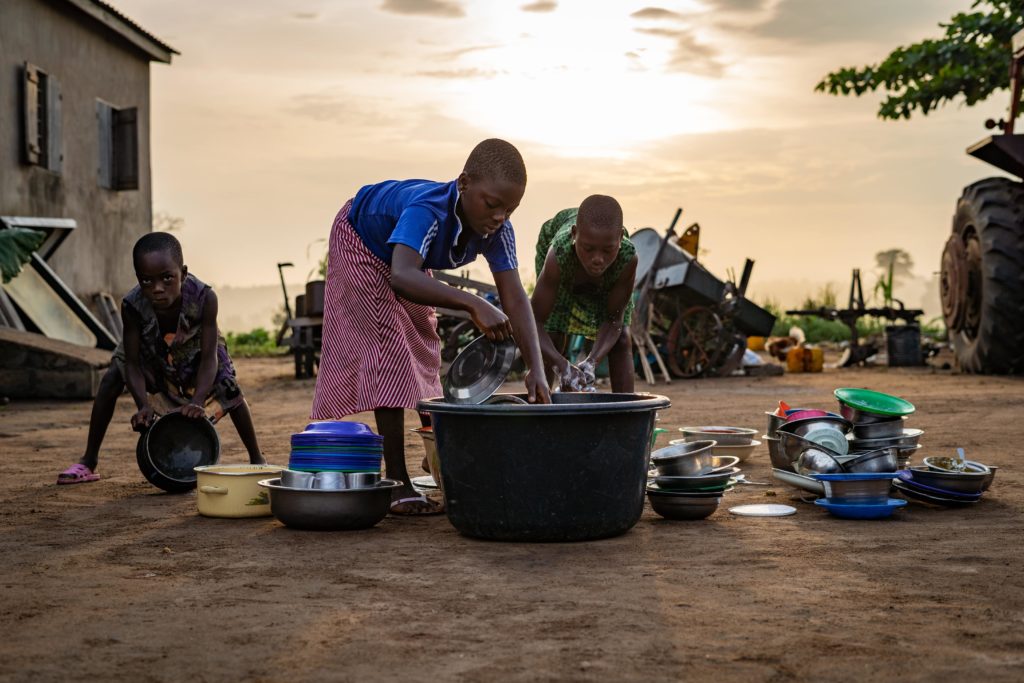 Des enfants font la vaisselle dans une bassine à Lomé au Togo