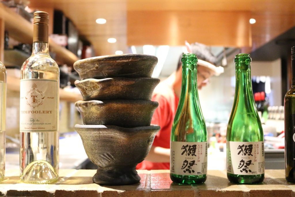 Bouteilles de vin et de saké avec coupes de saké